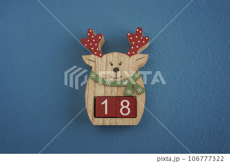 Festive wooden deer with Festive wooden deer with Viva Magenta cubes 18 on blue background close-up top view 106777322