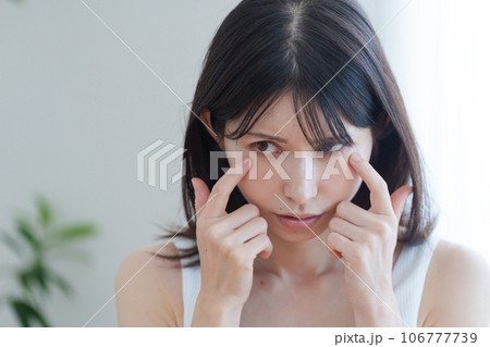 顔の目元に悩む女性 106777739