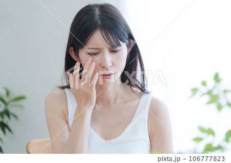 顔の目元に悩む女性 顔の目元に悩む女性 106777823