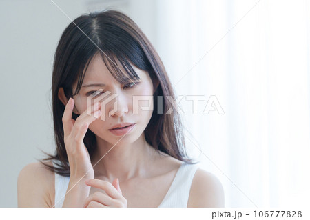 顔の目元に悩む女性 顔の目元に悩む女性 106777828