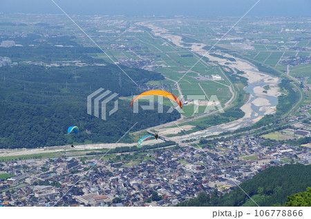 獅子吼高原から飛ぶパラグライダーと金沢平野の手取川扇状地 106778866