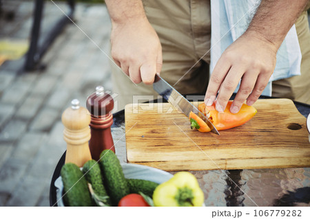 Unrecognizable man peeling sweet paprika with knife 106779282