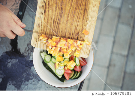 Top view of dropping chopped bell pepper to a salad bowl 106779285