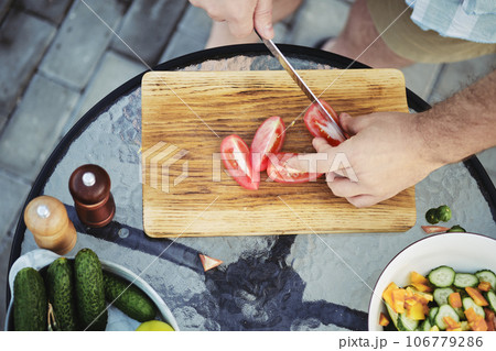 Slicing tomatoes for a vegetable salad 106779286