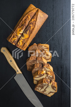 Marble sponge cake. Cake with cocoa and vanilla taste on black table. Top view. Marble sponge cake. Cake with cocoa and vanilla taste on black table. Top view. 106779772