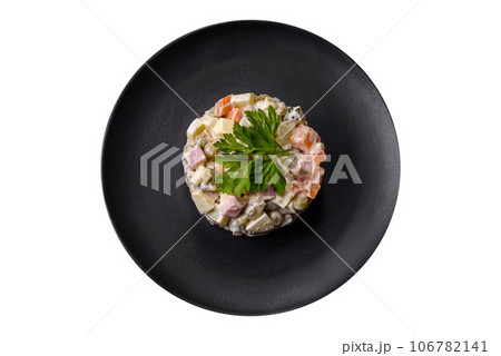 Delicious fresh Olivier salad with sausage, egg, cucumber, green peas, carrots and mayonnaise Delicious fresh Olivier salad with sausage, egg, cucumber, green peas, carrots and mayonnaise 106782141