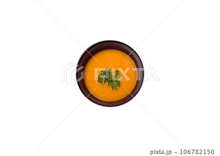 Delicious hot pumpkin and carrot soup puree with spices and herbs Delicious hot pumpkin and carrot soup puree with spices and herbs 106782150