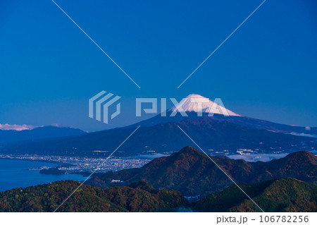 （静岡県）沼津アルプスと街灯りの向こうに雪化粧した富士山 106782256