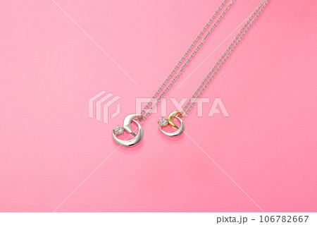 ピンク背景のアクセサリー・ピンク背景にオシャレなペアネックレス・オシャレなダイヤ入りペアネックレス ピンク背景のアクセサリー・ピンク背景にオシャレなペアネックレス・オシャレなダイヤ入りペアネックレス 106782667