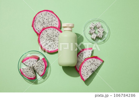 Concept of organic fruit with dragon fruit slices on petri dishes. Beauty container in green color featured. Dragon fruit (Hylocereus) is amazing for acne-prone skin 106784286