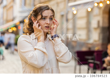 Sad unhappy frustrated young woman walking alone in city street, feeling bad, annoyed, grief problem 106784523