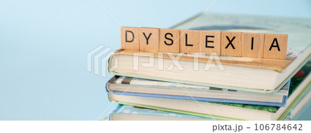 Dyslexia concept - name of disorder on books, blue background 106784642