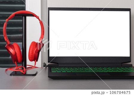 Gray Desk Setup with Laptop and Red Headphones. Blank white screen. 106784675