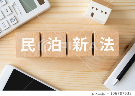 民泊新法と書かれたブロック、電卓、スマホ、ミニチュアの家 106787635