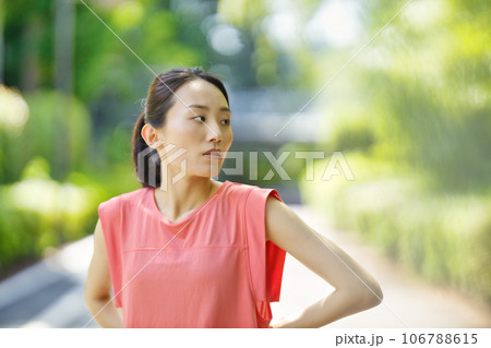 緑の中ストレッチをするスポーツウエアの若い女性 106788615