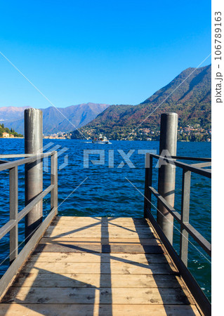 Wooden pier overlooking the Alps and Lake Como in Italy 106789163