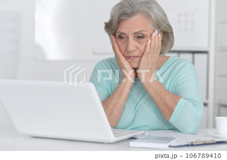 old woman with a laptop on a white background old woman with a laptop on a white background 106789410