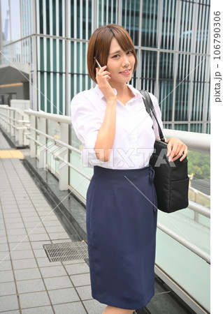 歩道橋の上でスマホで電話をする女性 106790306