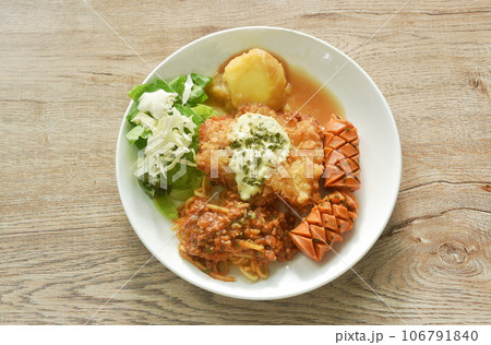 crispy fried chicken meat stuffed cheese with mash potato dressing gravy sauce and spaghetti and cabbage cos lettuce salad couple sausage on plate  106791840