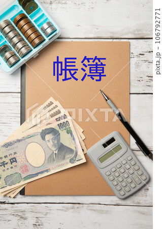 会計帳簿と現金と電卓のイメージ 106792771