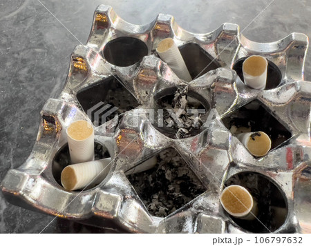 cigarette butts in ashtray on table cigarette butts in ashtray on table 106797632
