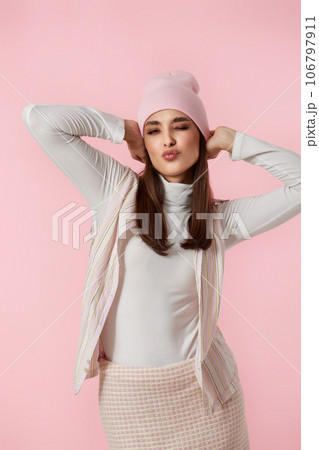 Happy playful young woman in pink hat, shirt and skirt 106797911