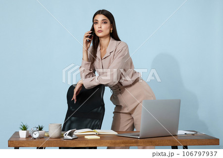 beautiful businesswoman in beige shirt using mobile phone 106797937