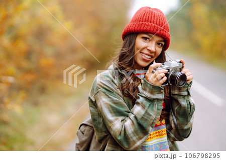 Beautiful young woman is photographed with retro camera. Rest, relaxation, travel, lifestyle concept 106798295