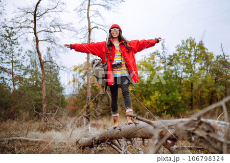 Young woman- tourist taking pictures in autumn forest. Rest, relaxation, tourism, lifestyle concept. 106798324