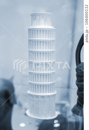 Art object printed on 3D printer. Figure Leaning Tower of Pisa prototype of white color. Model printed on 3D printer from melted plastic close-up. Concept new modern innovation printing technology Art object printed on 3D printer. Figure Leaning Tower of Pisa prototype of white color. Model printed on 3D printer from melted plastic close-up. Concept new modern innovation printing technology 106800132