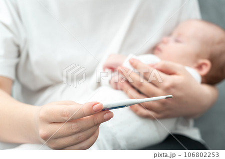 Concerned mother checks for fever in her newborn. Concept of infant health vigilance 106802253