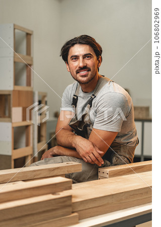 Portrait of young male carpenter standing in the wood workshop Portrait of young male carpenter standing in the wood workshop 106802969