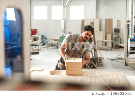Young man doing woodwork in carpentry factory Young man doing woodwork in carpentry factory 106803016