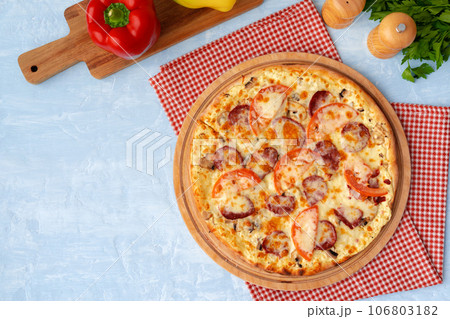 Delicious pizza with sausages on gray background Delicious pizza with sausages on gray background 106803182