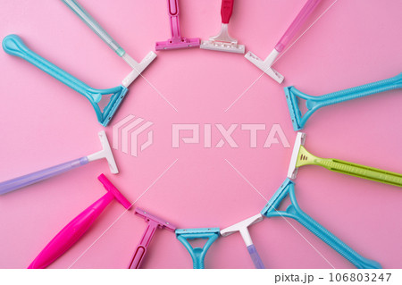 Female disposable razors on pink background top view 106803247