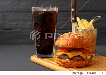 Tasty burger on black wooden background close up 106803384