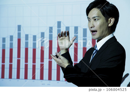 会議でプロジェクターを使ってプレゼンをする若いビジネスマンの男性 106804525