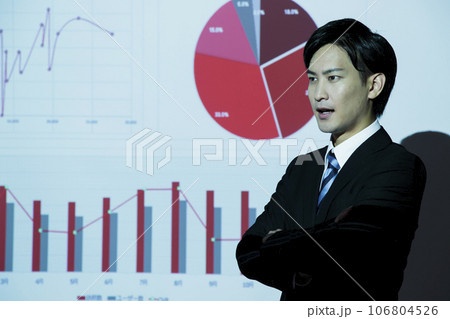 会議でプロジェクターを使ってプレゼンをする若いビジネスマンの男性 106804526
