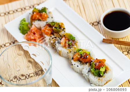 Sushi rolls with crab, cucumber, salmon, avocado seasoned with unagi sauce Sushi rolls with crab, cucumber, salmon, avocado seasoned with unagi sauce 106806093