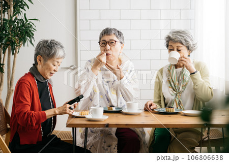 カフェでお茶をするシニア仲間・スマホを見るシニアの女性たち 106806638