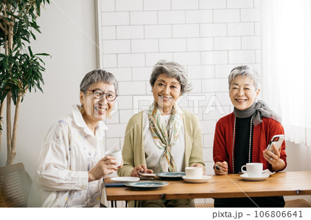 カフェでお茶をするシニア仲間・スマホを見るシニアの女性たち 106806641