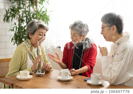 カフェでお茶をするシニア仲間・スマホを見るシニアの女性たち 106807776