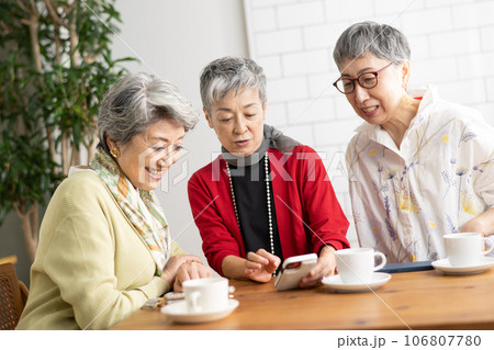 カフェでお茶をするシニア仲間・スマホを見るシニアの女性たち カフェでお茶をするシニア仲間・スマホを見るシニアの女性たち 106807780