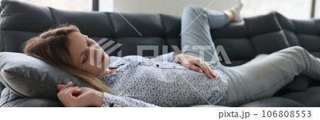 Woman feels tired and sleeps on sofa at home. 106808553