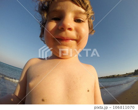 Adorable toddler baby playing with sand on a beach Adorable toddler baby playing with sand on a beach 106811070