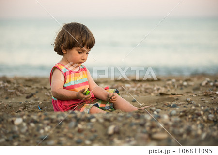 Toddler baby playing on a beach 106811095