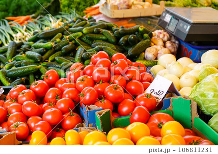 Various colorful fresh organic vegetables at a farmers market, tomatoes, cucumbers, onions, cabbage 106811231
