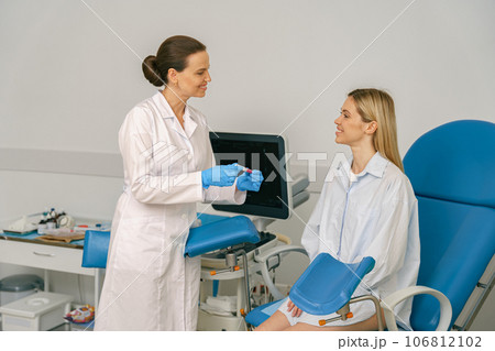 Female doctor showing positive pregnancy test for a pregnant woman at medical clinic 106812102