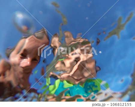 Underwater view of a father and her daughter with distorted faces having fun at the sea 106812155