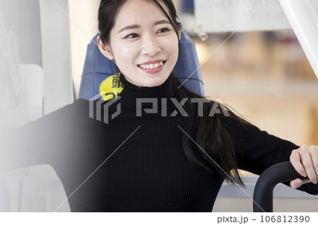 フィットネスジムで普段着でトレーニングをする若い女性　コンビニジムイメージ 106812390